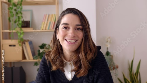 POV - point of view camera footage of young adult woman having an online video call talking to the camera at home office. Portrait of cheerful entrepreneur female during chat video conference. 