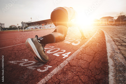 Athletes who start running on a rubber track with a bright sunset, blurred background. Ideas for starting something new, starting a new thing, starting a successful one, leading an organization	 photo