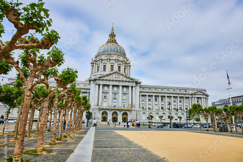 Sandy entrance leading to pedestrians in front of city hall with mangled oak trees