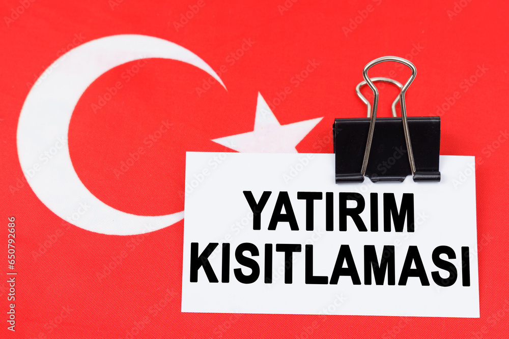 Fototapeta premium On the flag of Turkey lies a business card with the inscription - investment restriction