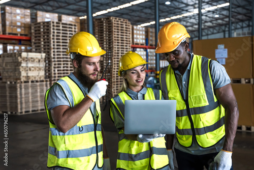 Black factory worker man and teammates working together with computer notebook in distribution warehouse  photo