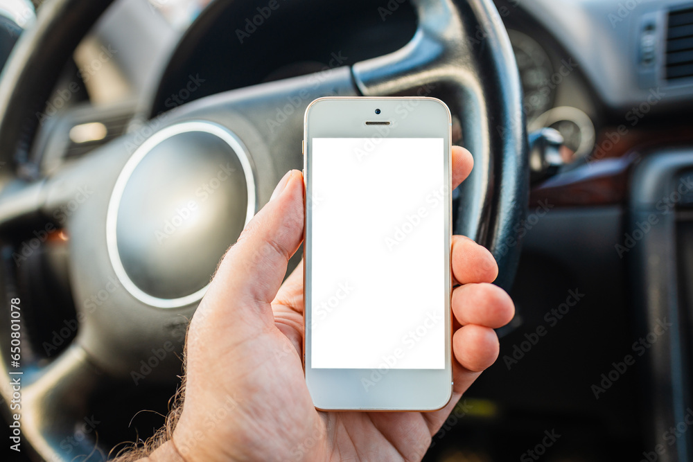 Blank screen Mockup of man driver hand using blank white screen mobile smart phone inside a car, searching location via gps navigator application, closeup. Blank screen Mockup of man driver hand using blank white screen mobile smart phone inside a car, searching location via gps navigator application, closeup.