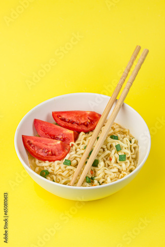 Plate of instant noodles on yellow background
