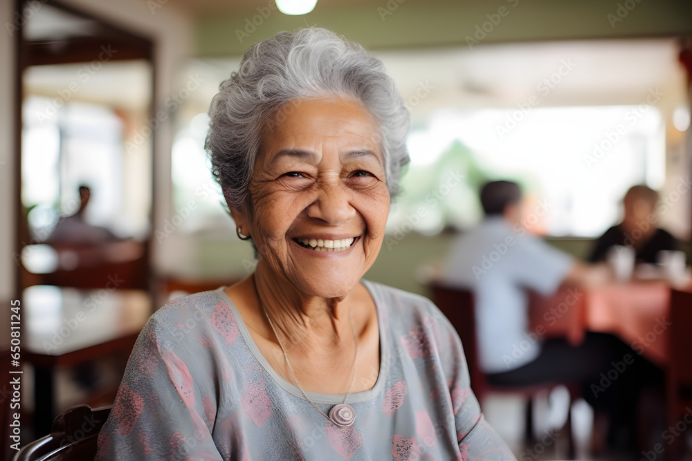 Smiling portrait of a happy senior latin or mexican woman in a nursing home - obrazy, fototapety, plakaty 