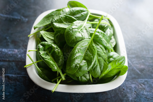 Fresh spinach leaves in a bowl, green vegetables, rustic style, healthy lifestyle, proper nutrition.