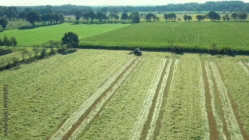 A tractor turns up the grass, aerial view. Tractor during harvesting. Ecological agriculture. photo