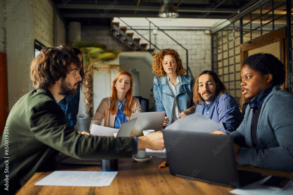 Young and diverse group of designers having a meeting in an office while working in a startup company Young and diverse group of designers having a meeting in an office while working in a startup company
