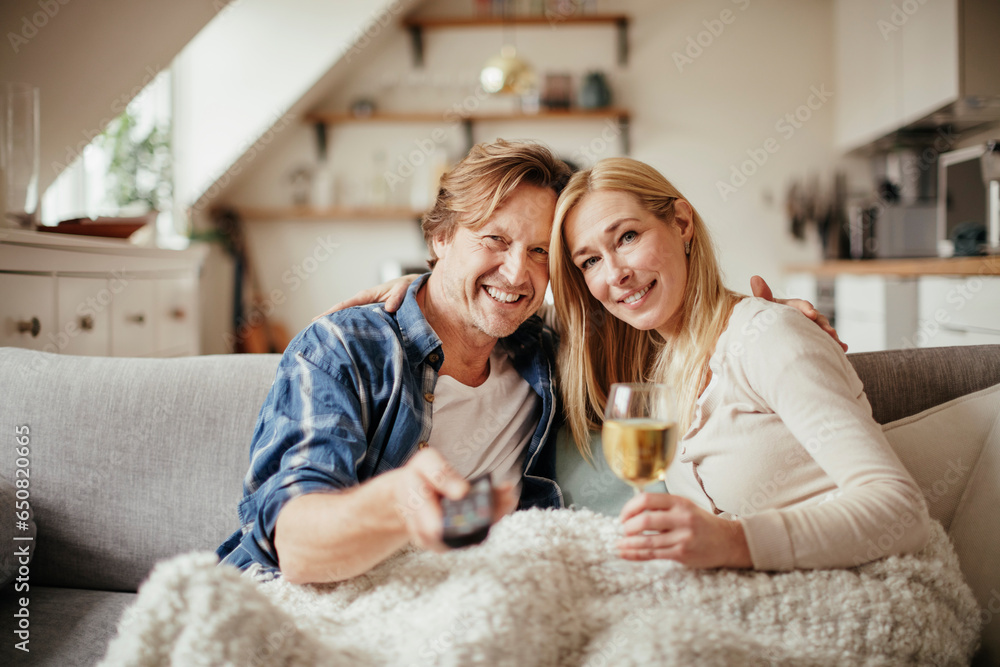 Portrait of a middle aged Caucasian couple using the tv on date night in the living room at home Portrait of a middle aged Caucasian couple using the tv on date night in the living room at home