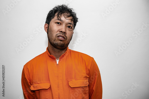 Prisoner in orange robe concept,Portrait of asian handsome man in Prison uniforms,Bandit has a lot of muscle,