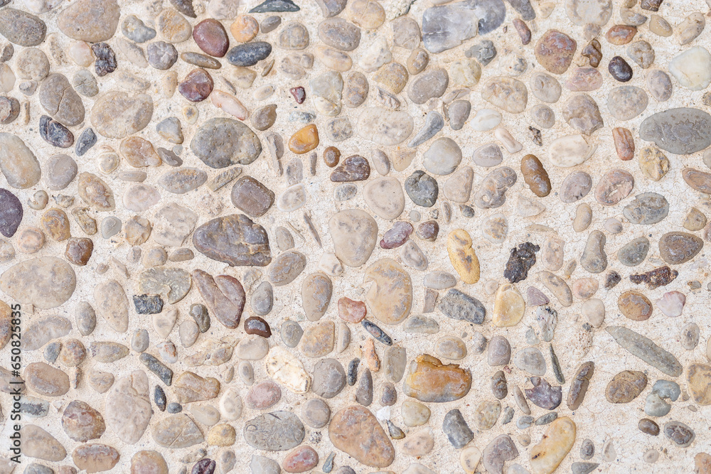 Close up background of flat stones. Stone texture. Rough surface of small stones. White, gray, yellow, yellow, brown and reddish stones. Close up background of flat stones. Stone texture. Rough surface of small stones. White, gray, yellow, yellow, brown and reddish stones.