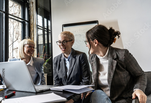 A group of casual female marketing executives engages in a lively meeting at their relaxed office  brainstorming and discussing innovative ideas with enthusiasm.