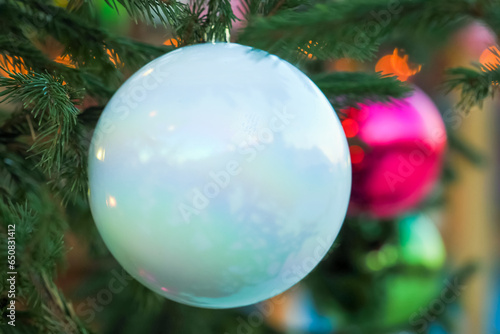 Christmas decorations, christmas tree,  White matte Christmas ball on a branch of a festive spruce