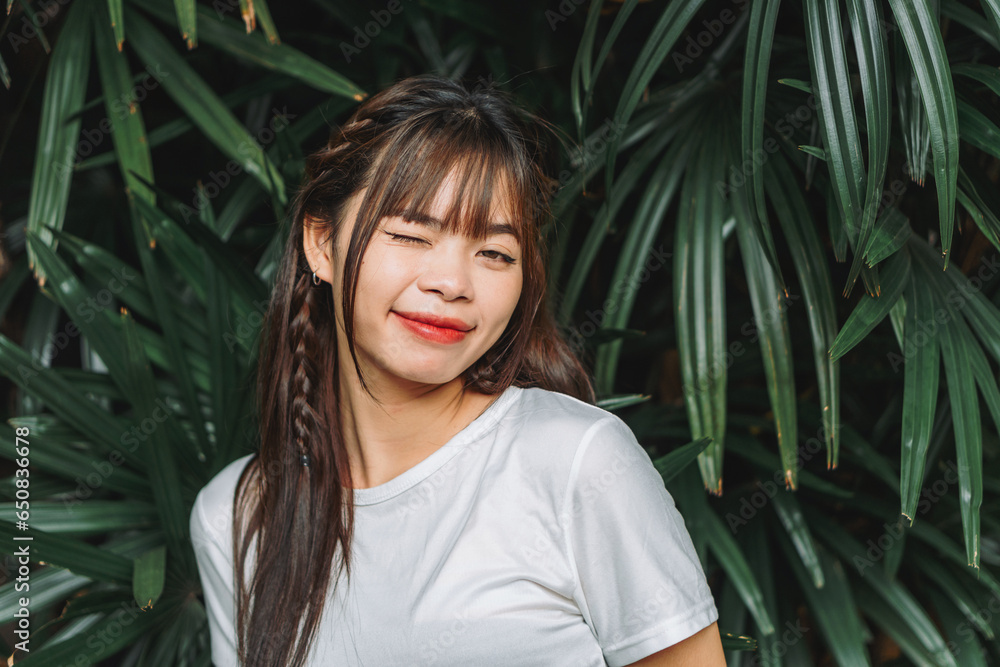 Portrait of beautiful asian woman smiling with enjoying the nature on background of green leaves tropical wild aesthetic exotic concept, Zen, love forest Portrait of beautiful asian woman smiling with enjoying the nature on background of green leaves tropical wild aesthetic exotic concept, Zen, love forest