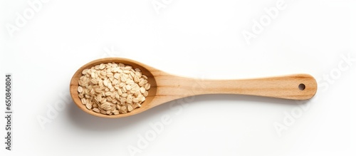 Oatmeal and wooden spoon arranged creatively on a white background from above
