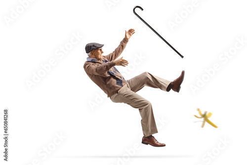 Photography Older man with a walking cane slipping on a banana skin
