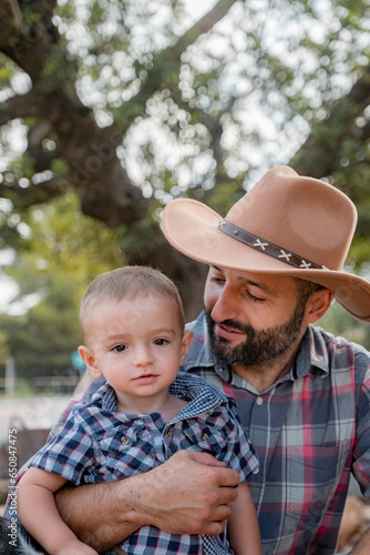son and his father dressed as cowboys in the mountains
