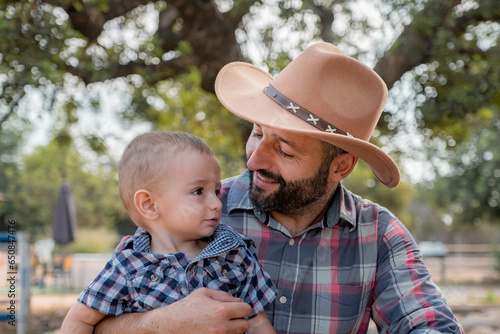 son and his father dressed as cowboys in the mountains