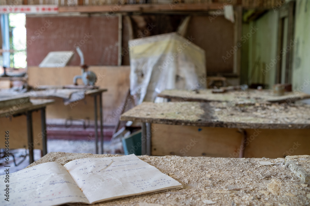 Classroom in an abandoned school with notebooks on desks in the exclusion zone of Belarus.