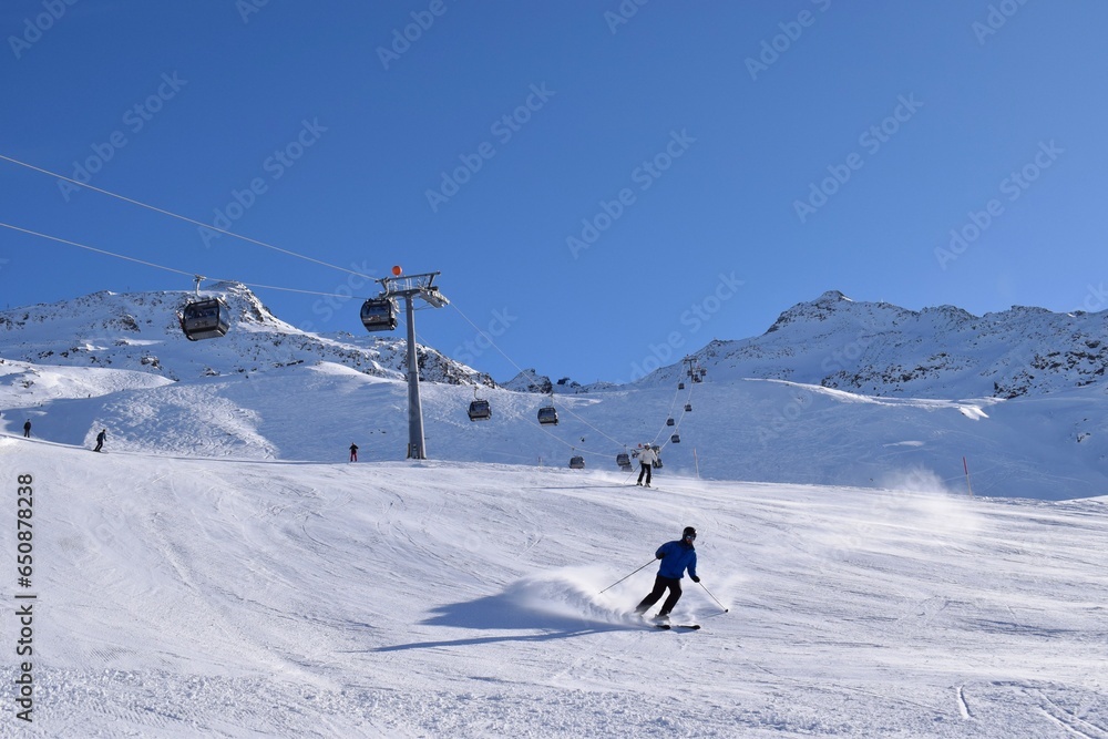 Downhill skiers in Hochgurgl ski resort on a beautiful sunny day, perfect conditions for winter sport, skiing and snowboarding in the snow capped alpine mountains in the Ötztal valley, Tyrol, Austria. Downhill skiers in Hochgurgl ski resort on a beautiful sunny day, perfect conditions for winter sport, skiing and snowboarding in the snow capped alpine mountains in the Ötztal valley, Tyrol, Austria.