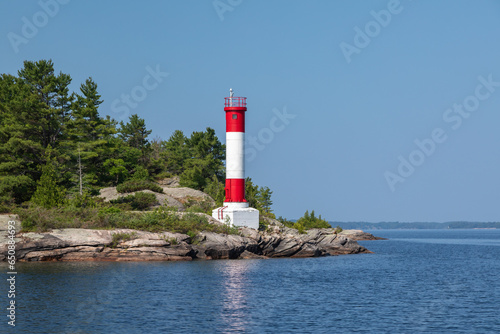 A Red and White Lighthouse on a Point of Land on Clear Blue Sky Summer Day in Parry Sound, Lake Huron, Georgian Bay, Ontario, Canada