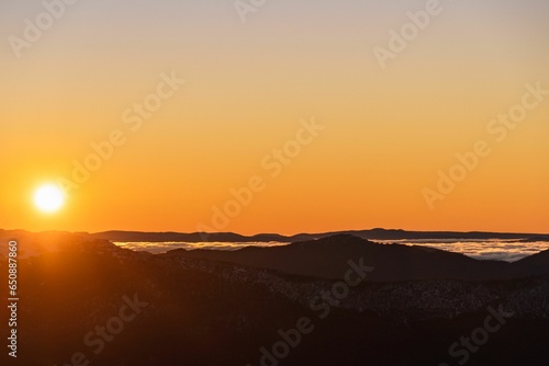 Wallpaper Mural the sun setting on a mountain with clouds in the foreground Torontodigital.ca