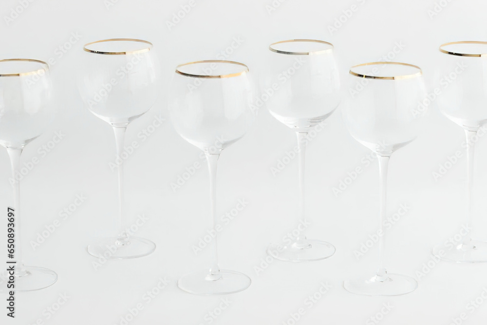 Set of empty wine glasses in a row on white background
