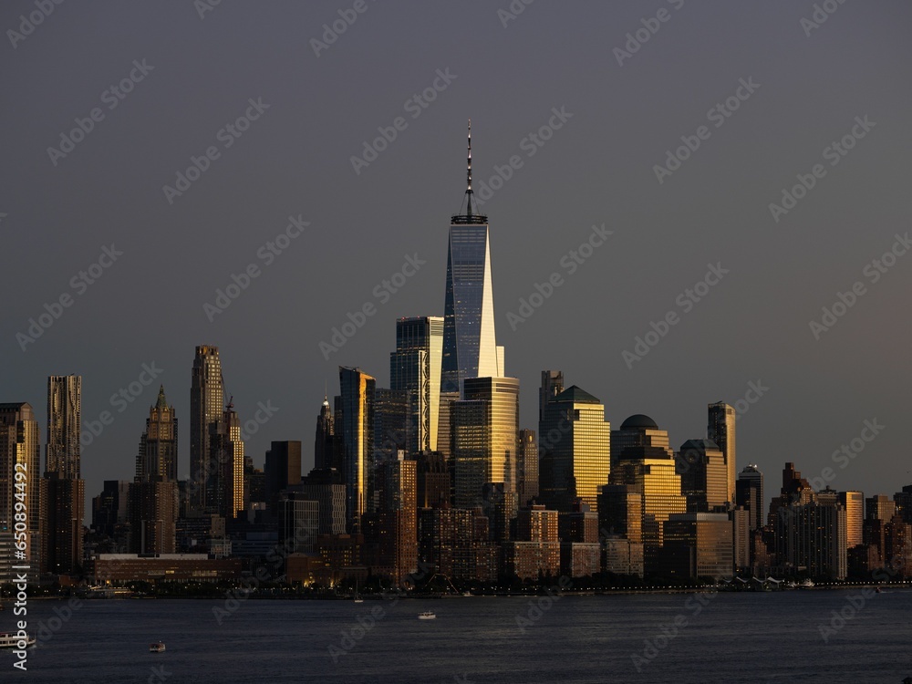 Fototapeta premium Manhattan Cityscape surrounded by a river in the evening in New York City