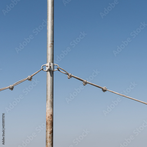um cabo de aço e um poste sob um céu azul típico de outono