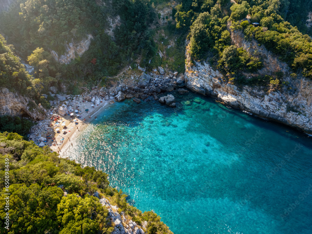Aerial view of the beach at Fakistra, Pelion mountain, Greece, with emerald shining sea surounded by thick pine tree forest