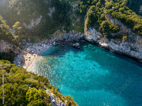Aerial view of the beach at Fakistra, Pelion mountain, Greece, with emerald shining sea surounded by thick pine tree forest