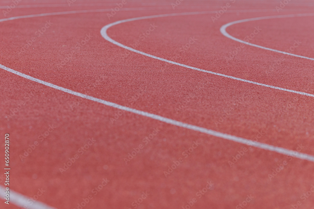 Close-up of the burgundy running track around the stadium illuminated by the morning light