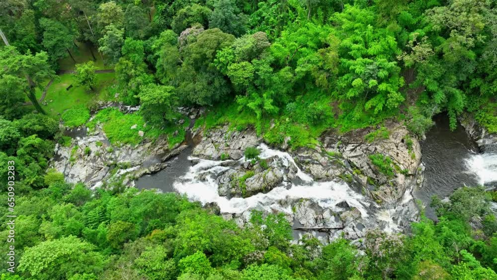 Khlong Nam Lai Waterfall, situated within the lush green tropical forest of Khlong Lan National Park, is a natural masterpiece that exemplifies the beauty of nature in Thailand. Drone aerial view.
