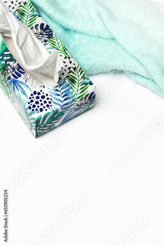 Box with tissues and scarf on white background