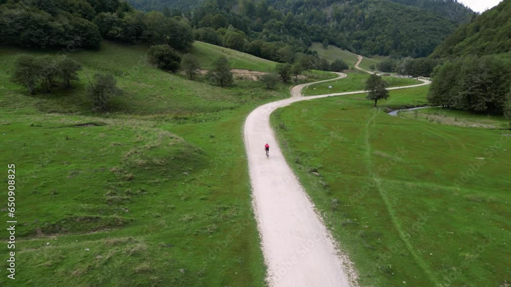 Gravel cycling in mountains. Aerial drone shot of cyclist riding beautiful epic setting landscape.Biking adventures.Amazing recreational sport activity for healthy lifestyle.Biker riding on dirt road. Gravel cycling in mountains. Aerial drone shot of cyclist riding beautiful epic setting landscape.Biking adventures.Amazing recreational sport activity for healthy lifestyle.Biker riding on dirt road.