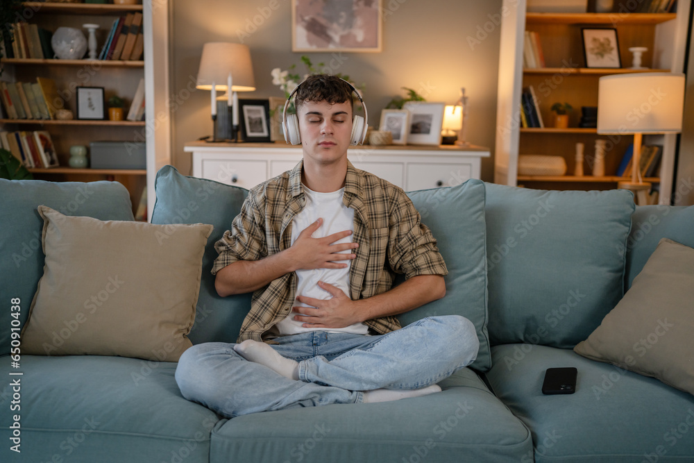 Obraz premium One teen man doing guided meditation yoga self care practice at home