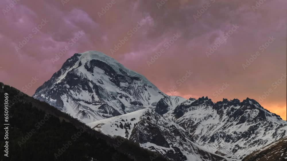Beautiful time-lapse in the mountains. Snow covered mountains and clouds at the sunset timelapse. Georgia, Kazbeg mountains. Beautiful time-lapse in the mountains. Snow covered mountains and clouds at the sunset timelapse. Georgia, Kazbeg mountains.