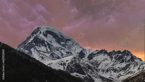 Beautiful time-lapse in the mountains. Snow covered mountains and clouds at the sunset  timelapse. Georgia, Kazbeg mountains. photo