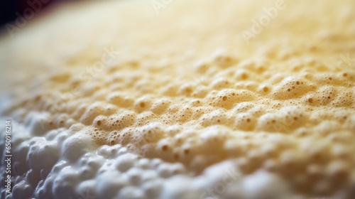 Macro shot of a fermentation tank, covered in a thick layer of frothy foam produced during the fermentation process. photo