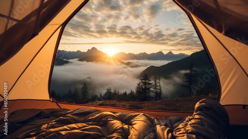 View from camping tent with sunrise, clouds, and mountains background.