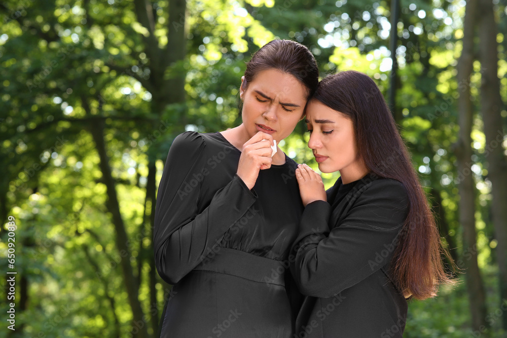 Sad women in black clothes mourning outdoors. Funeral ceremony Sad women in black clothes mourning outdoors. Funeral ceremony