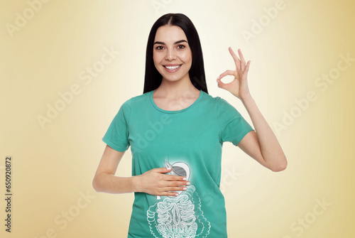 Obraz na płótnie Happy woman with healthy digestive system on light yellow background