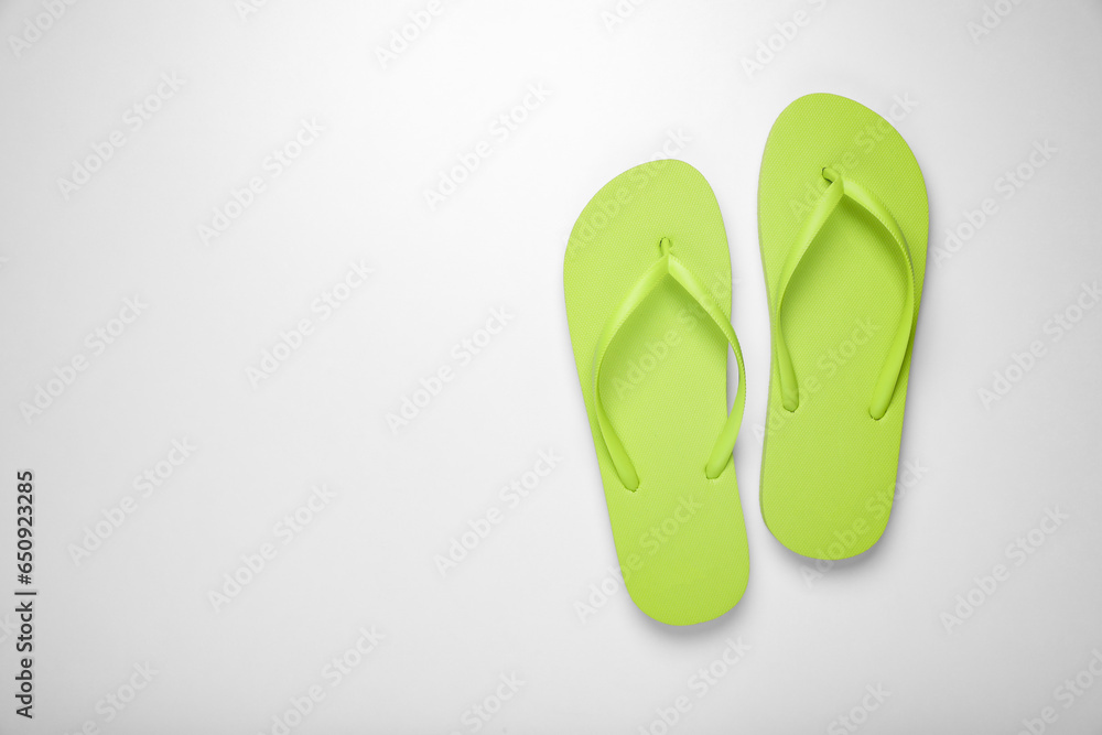 Light green flip flops on white background, top view. Space for text Light green flip flops on white background, top view. Space for text
