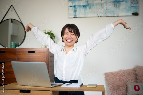 パソコンの前で喜んでる女性 photo