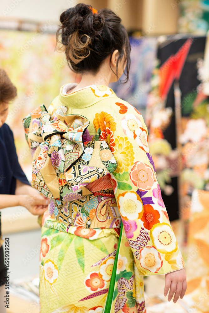 着付けをしてもらう女性の後姿 着付けをしてもらう女性の後姿