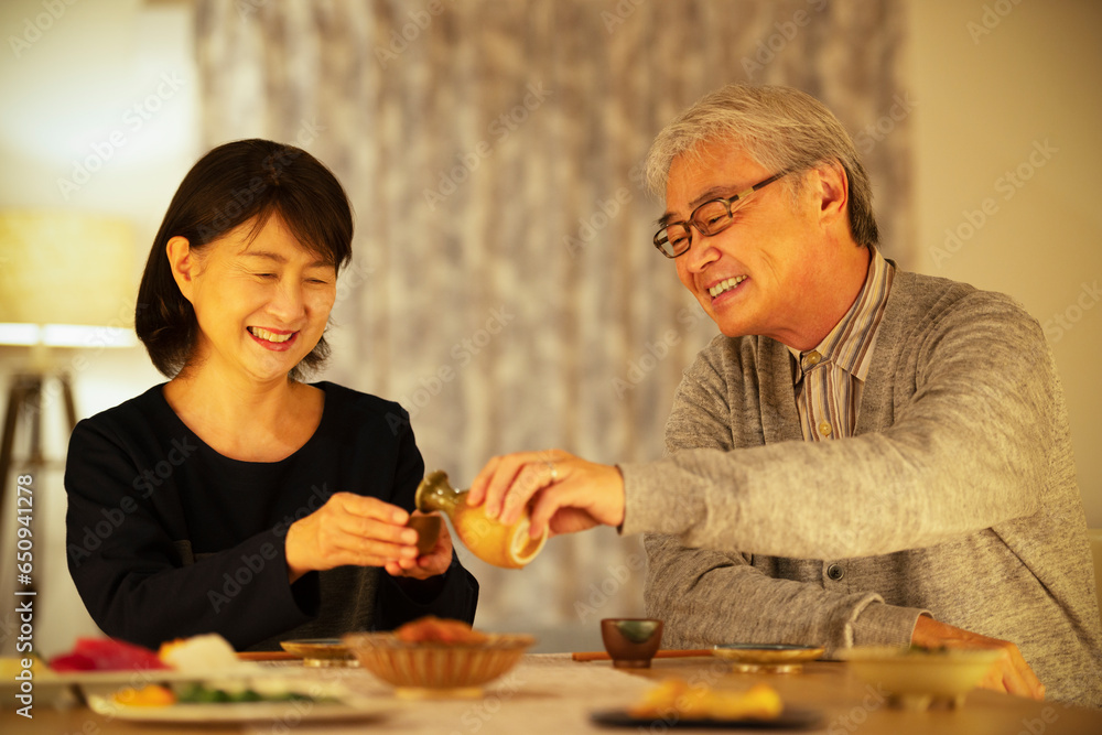 日本酒で晩酌をするシニア夫婦 日本酒で晩酌をするシニア夫婦