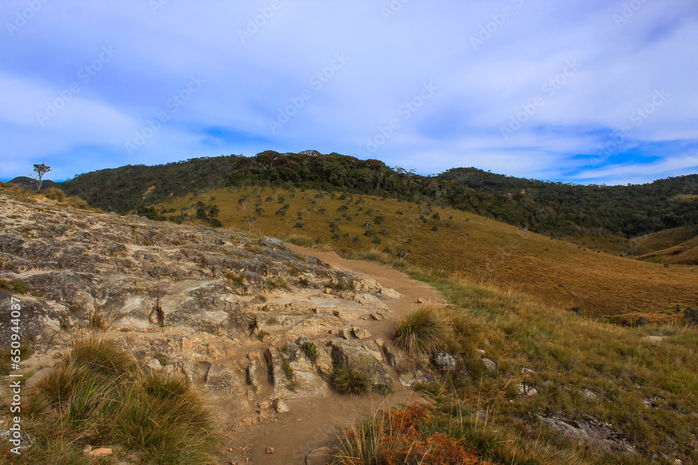 Blue morning sky above the rocks and trail through the Horton Plains, Sri Lanka