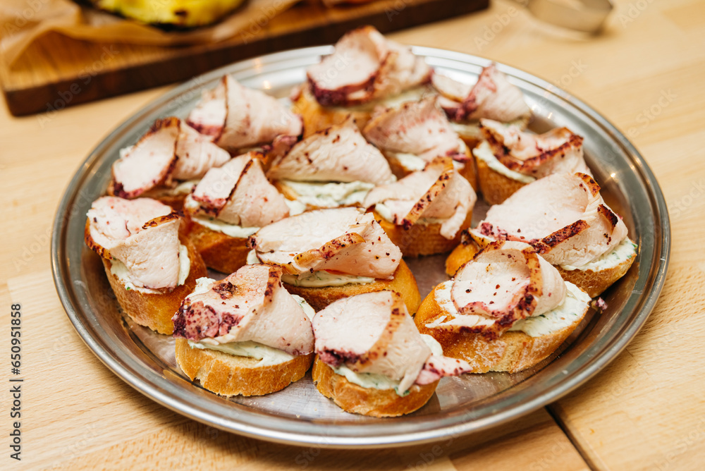 bruschetta with turkey meat and bazhe nut sauce, many servings on a tray, on a wooden table bruschetta with turkey meat and bazhe nut sauce, many servings on a tray, on a wooden table