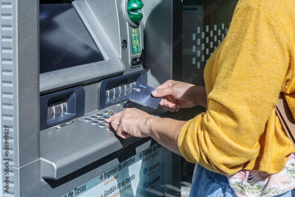 close-up of woman withdrawing cash from an automatic cash dispenser close-up of woman withdrawing cash from an automatic cash dispenser
