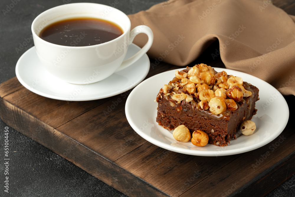 Brownie cake with nuts topping on plate close up Brownie cake with nuts topping on plate close up