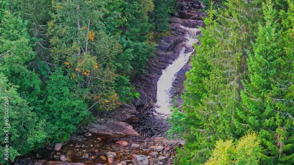 Revealing shot of a waterfall in a creek in late summer Revealing shot of a waterfall in a creek in late summer